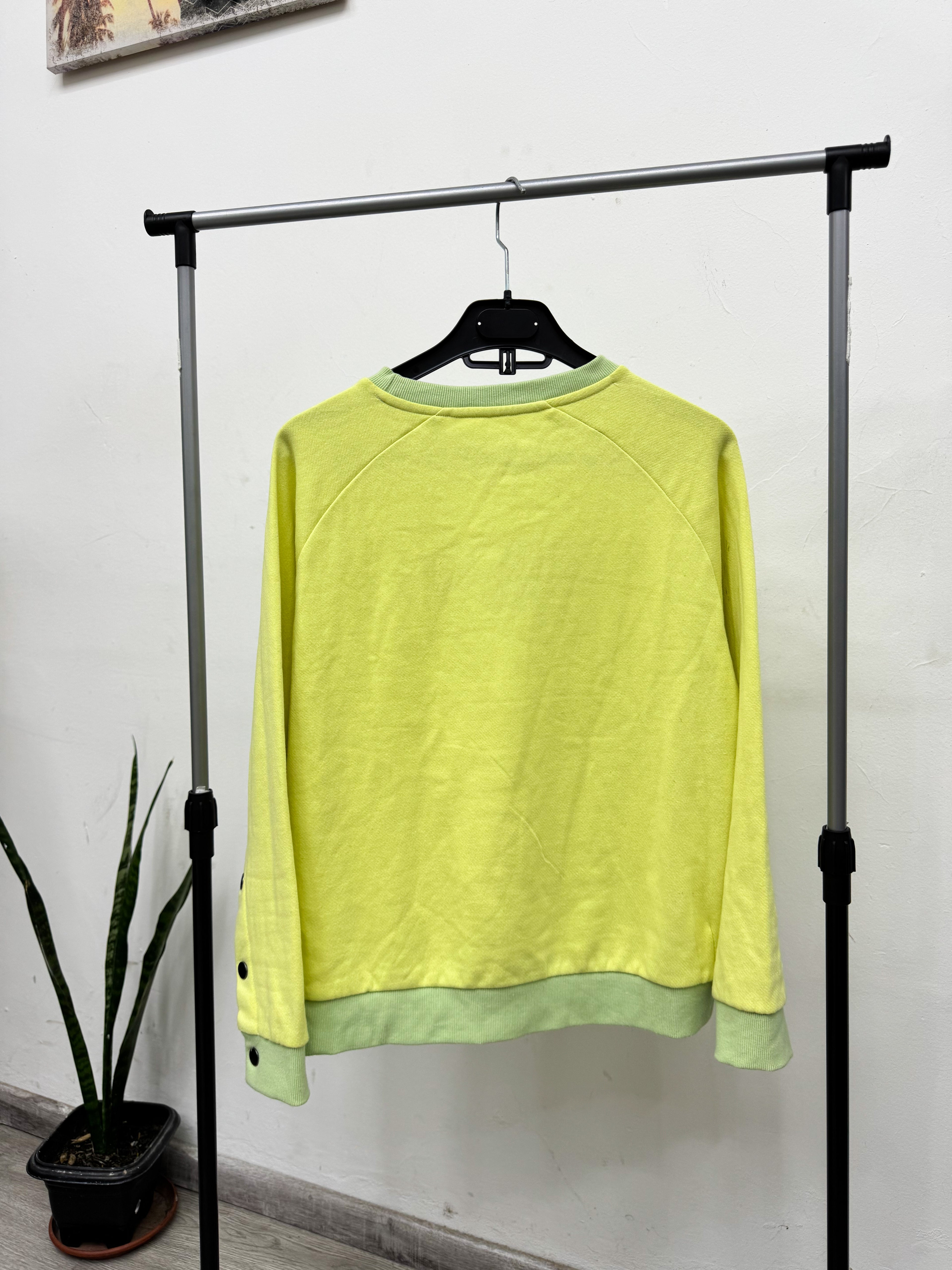 Buzo amarillo y verde con botones en las mangas