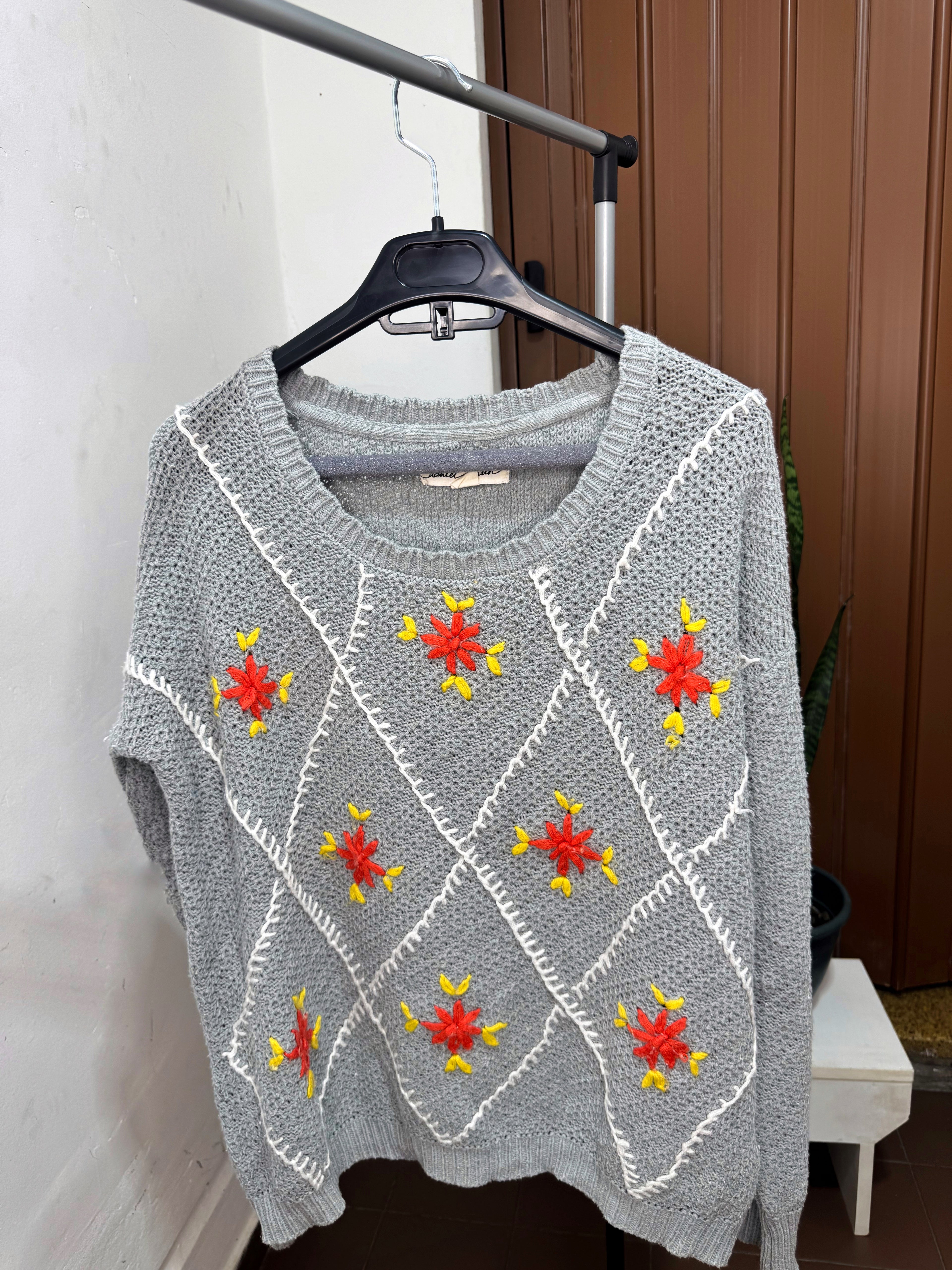 Buzo gris con flores naranjas