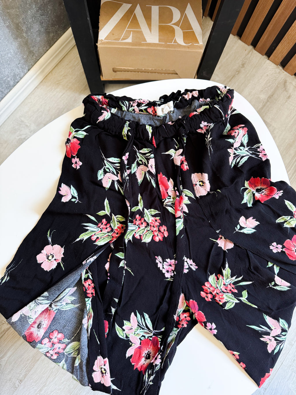 Pantalón suelto negro, abierto y floreado con lazo