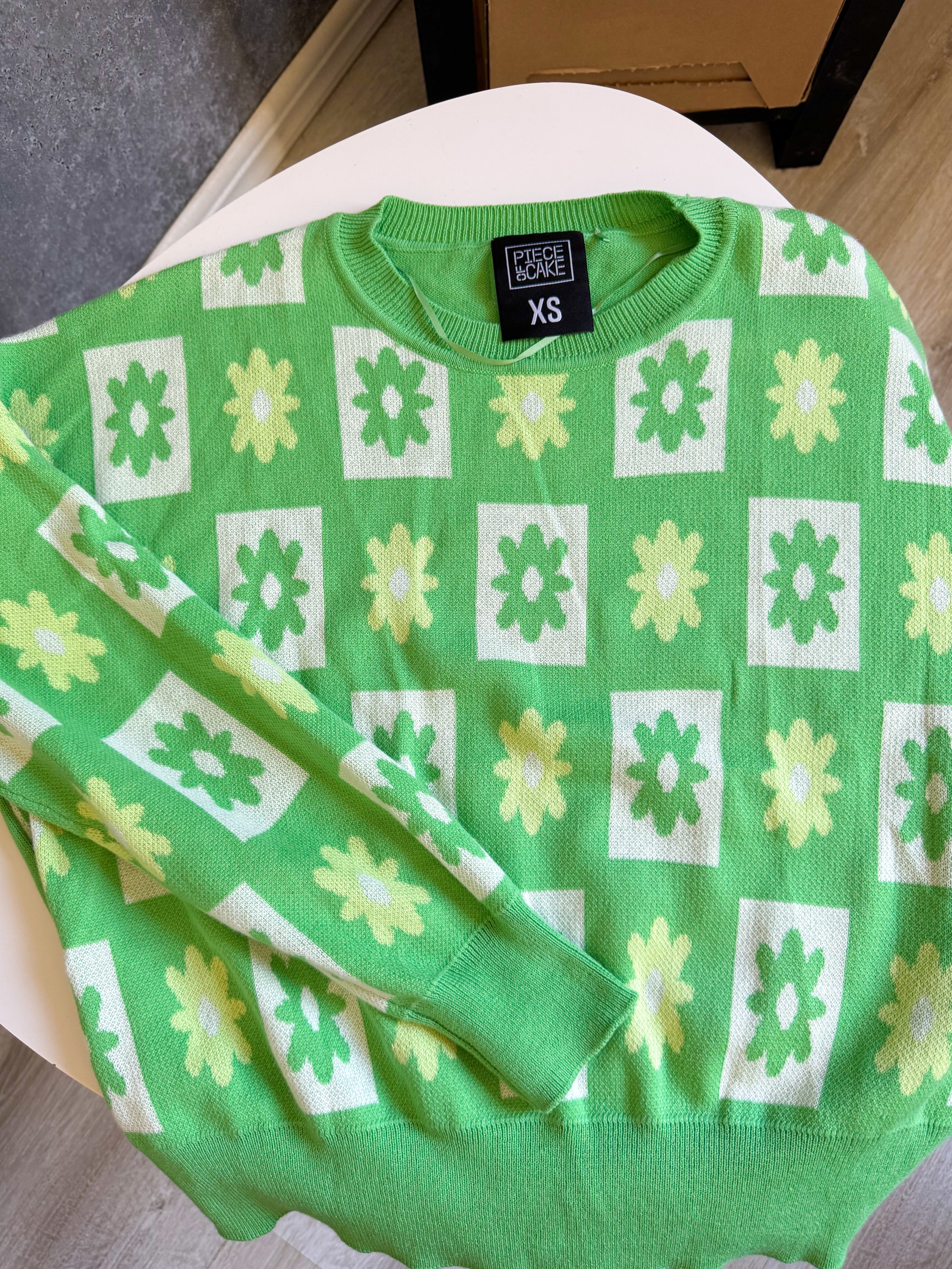 Buzo verde con flores de hilo