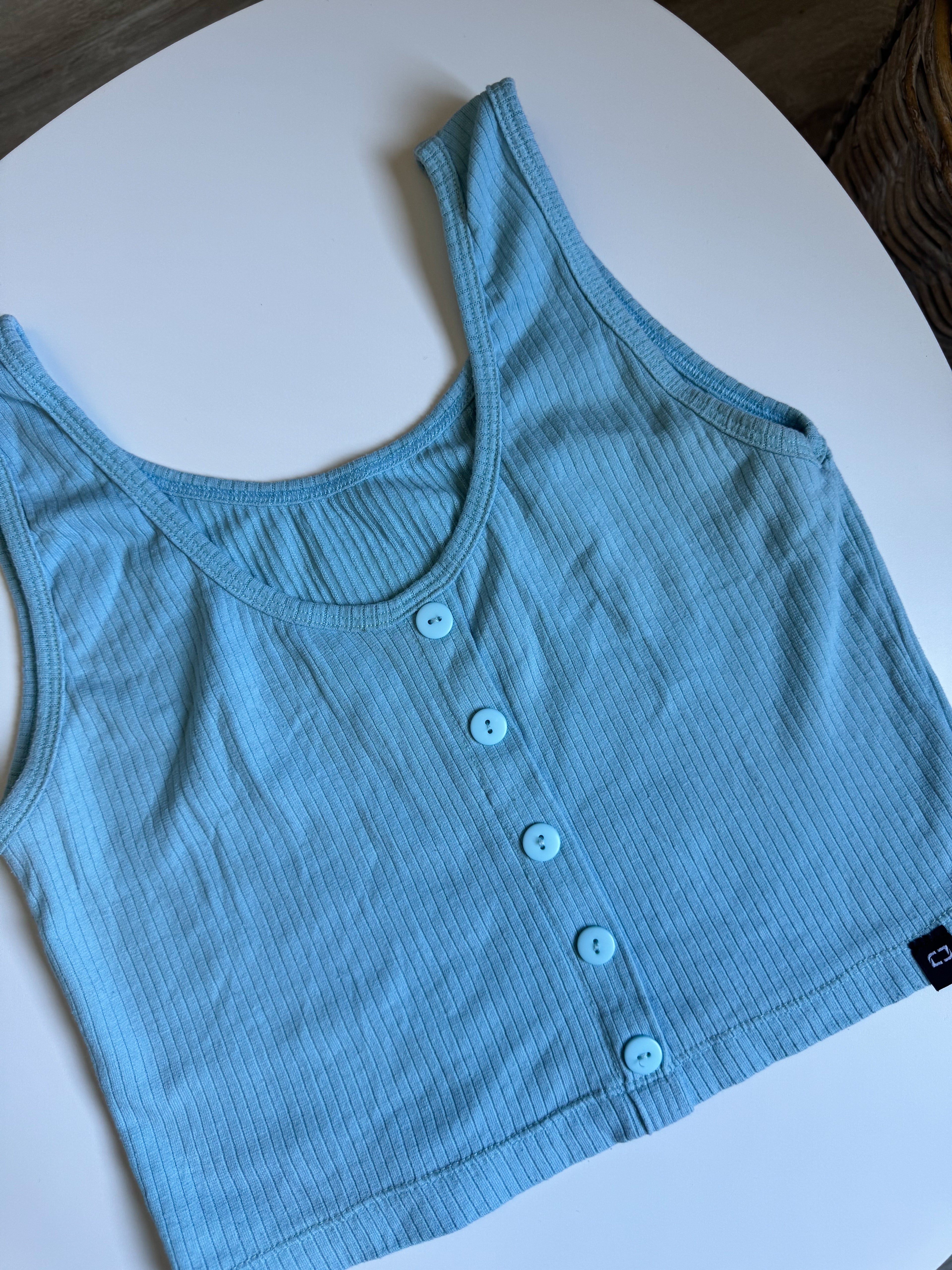 Top celeste con botones adelante